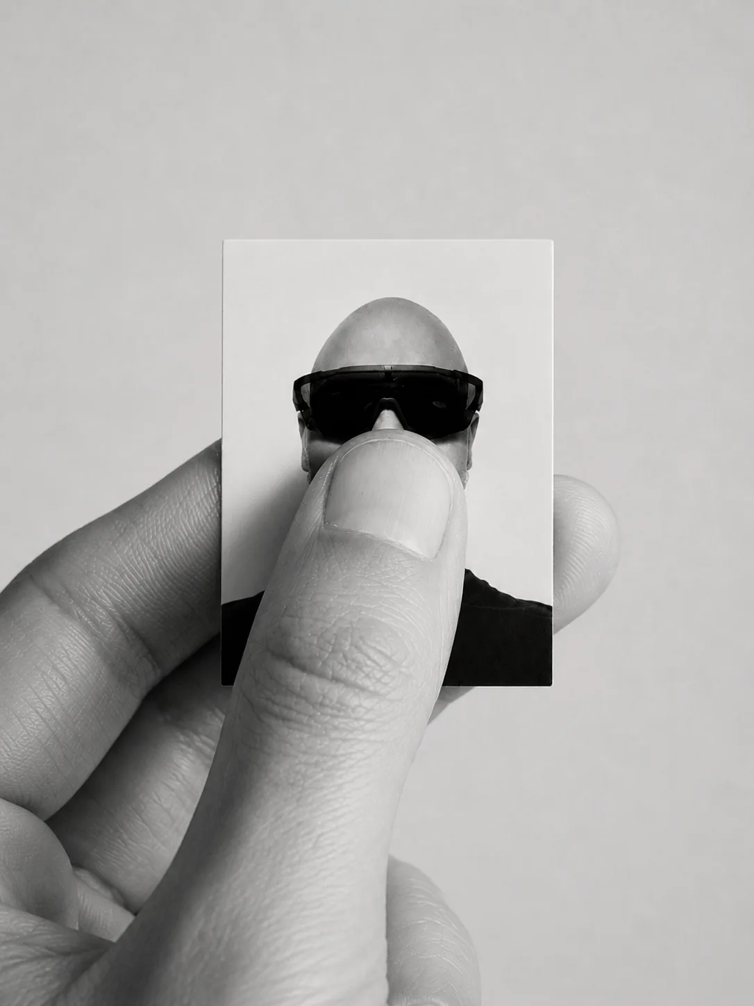 A hand holding a miniature monochrome portrait.